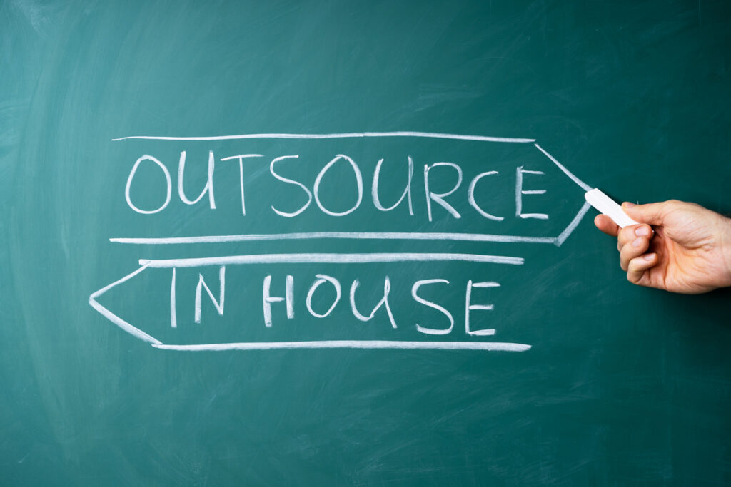 inhouse and outsource written on a chalkboard