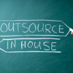 inhouse and outsource written on a chalkboard